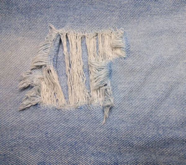 Textura Jeans Azul Tem Uma Lágrima Visível Tecido Branco Dentro — Fotografia de Stock