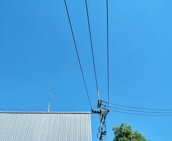 Mavi gökyüzü ile fabrikaya bağlı elektrik direkleriyle elektrik üretimi fikri veriliyor..