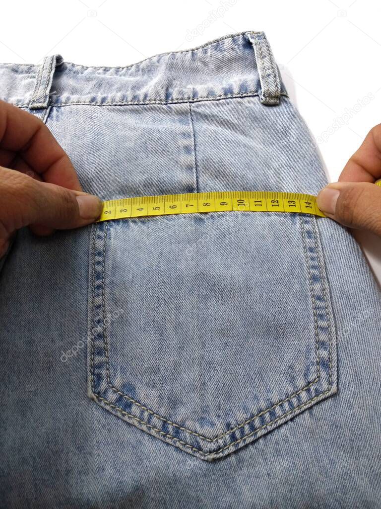 Hand jeans are pulling the yellow tape measure.  Give an idea of measuring the waist circumference cut out the clothes