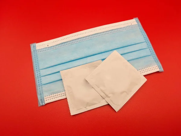Kondom Med Hygienmask Röd Bakgrund Förebyggande Utbrott Infektionssjukdomar — Stockfoto