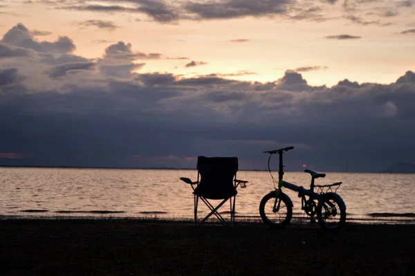 Puste Krzesła Przy Rowerach Plaży Zmierzch Silnymi Czarnymi Chmurami Porze — Zdjęcie stockowe