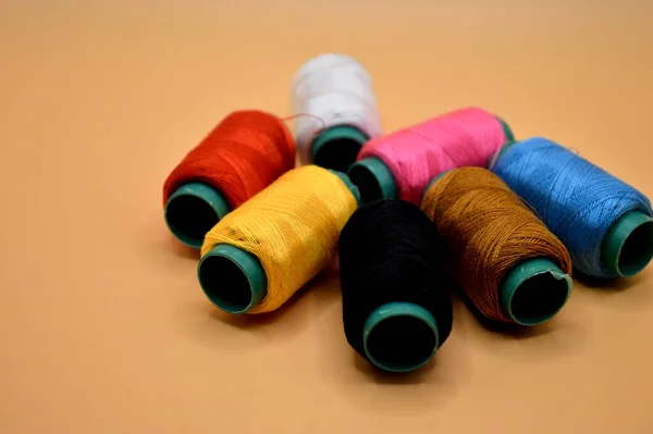 Colorful Thread Rolls Orange Background Garment Accessories Concept — Zdjęcie stockowe