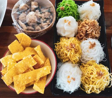 Boat noodles consisting of beef, noodles, laid on a brown wooden table. Concept, a famous dish and popular with Teens and Asians.