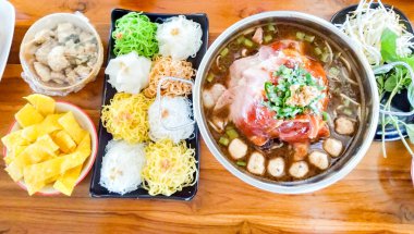 Boat noodles consisting of beef, noodles, laid on a brown wooden table. Concept, a famous dish and popular with Teens and Asians.