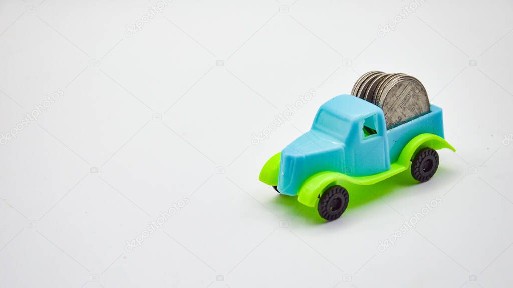 Silver coins stacked on a blue-green truck.  white background concept car insurance policy financial business