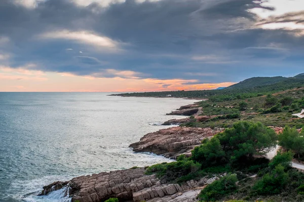 İspanya 'nın Peniscola kentindeki Sierra de Irta doğal parkında gün batımında kıyı şeridi manzarası