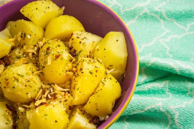 Bir kase dolusu haşlanmış patates ve beste yapmak için yeşil bir bez..