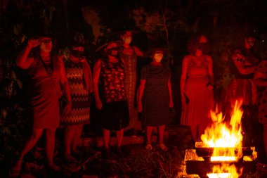 Kamp ateşi etrafında birkaç kadın. Kızıl Cadılar Gecesi, Başkan Jair Bolsonaro 'ya karşı siyasi odaklı bir Cadılar Bayramı etkinliğiydi..