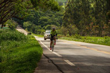 Otoyolda pedal çeviren bir bisikletçi. Gois 'deki GO-462 otoyolunun bir bölümünün manzarası.