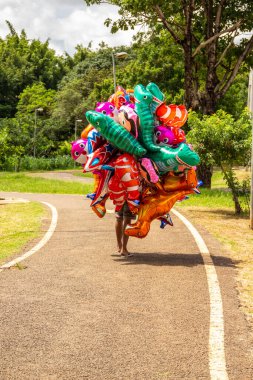 Parktaki balon satıcısı. Tüm vücudunu saklayan bir kaç balon tutan kişi..