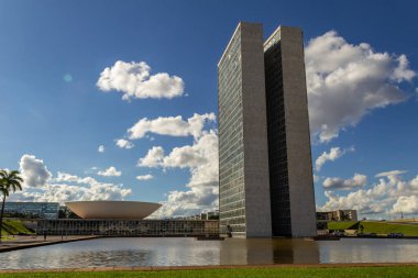 Su aynasında yansıması olan Ulusal Kongre Sarayı bulutlu bir günde.