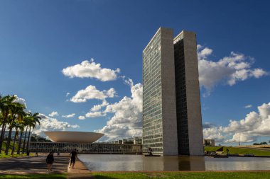 Su aynasında yansıması olan Ulusal Kongre Sarayı bulutlu bir günde.