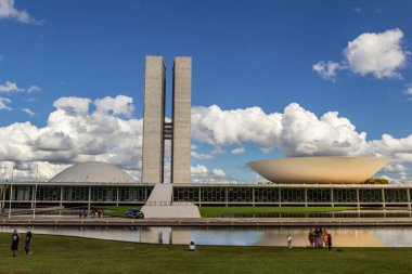 Su aynasında yansıması olan Ulusal Kongre Sarayı bulutlu bir günde.
