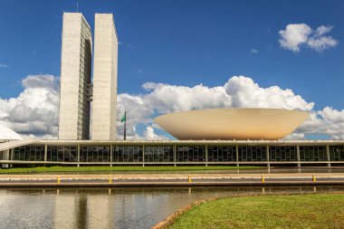 Su aynasında yansıması olan Ulusal Kongre Sarayı bulutlu bir günde.