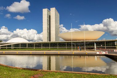 Su aynasında yansıması olan Ulusal Kongre Sarayı bulutlu bir günde.