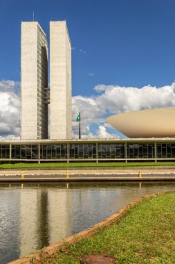 Su aynasında yansıması olan Ulusal Kongre Sarayı bulutlu bir günde.