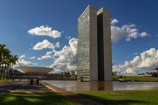 Su aynasında yansıması olan Ulusal Kongre Sarayı bulutlu bir günde.