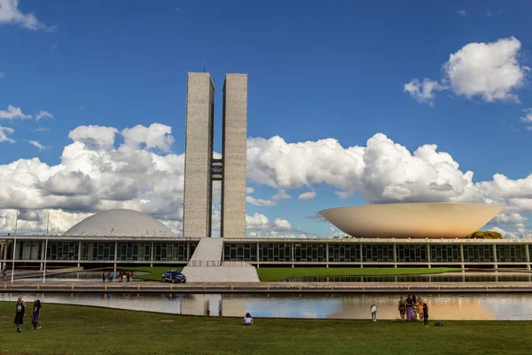 Su aynasında yansıması olan Ulusal Kongre Sarayı bulutlu bir günde.