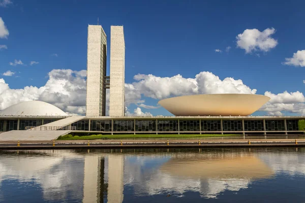Su aynasında yansıması olan Ulusal Kongre Sarayı bulutlu bir günde.