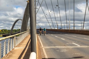 Braslia 'daki JK köprüsünden geçen iki bisikletçi.