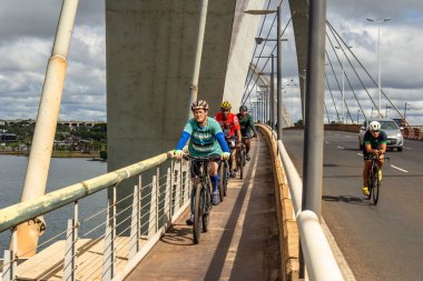Bazı bisikletçiler Braslia 'daki JK köprüsünden geçiyor.