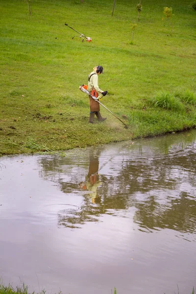 Worker Who Cuts Grass Edge Lake Using Appropriate Equipment — Stockfoto