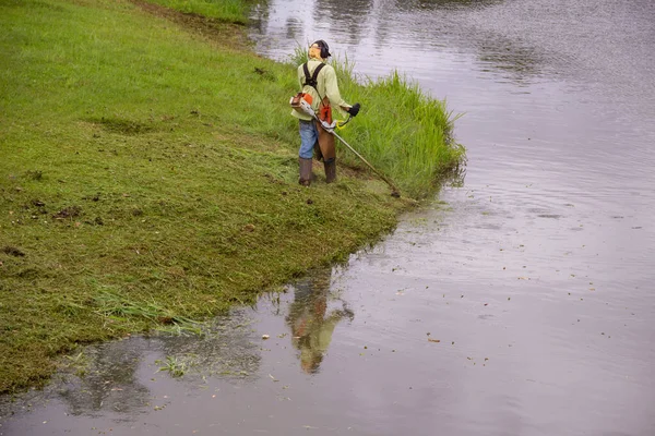 Ein Arbeiter Der Rande Eines Sees Mit Entsprechender Ausrüstung Gras — Stockfoto
