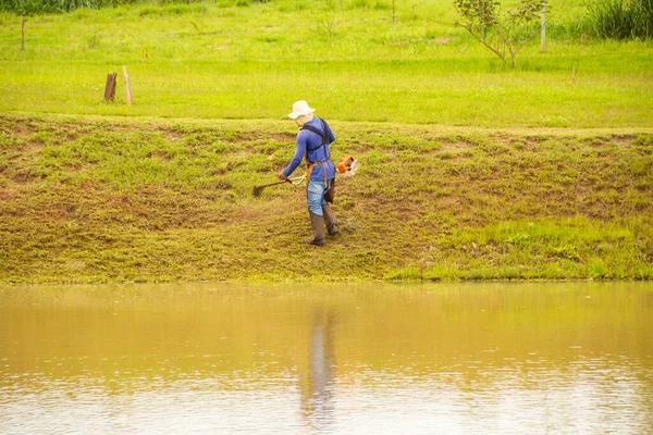 Worker Who Cuts Grass Edge Lake Using Appropriate Equipment — Stockfoto