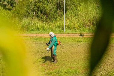 Belediye binasında halka açık bir parkta bahçe bakımı yapan bir profesyonel. Çimleri buduyorum..