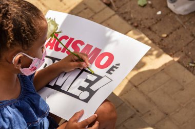 Beyaz bir gül tutan siyah bir kız ve üzerinde 
