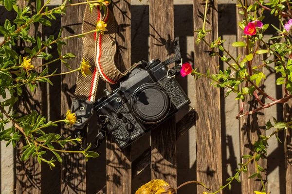 Eine Alte Fotokamera Zwischen Bunten Blumen Auf Einer Holzoberfläche — Stockfoto