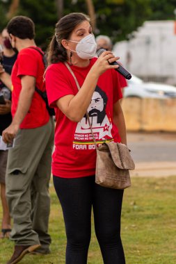 Mikrofona konuşan bir kadın. Fotoğraf, Goiania şehrinde Başkan Bolsonaro 'ya karşı düzenlenen bir protesto sırasında çekildi..