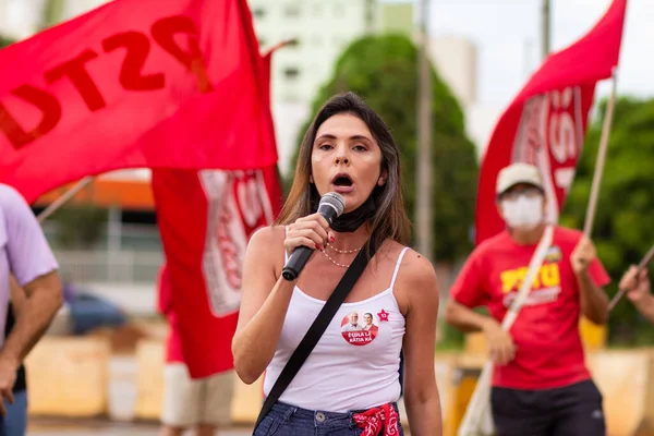 Mikrofona konuşan bir kadın. Fotoğraf, Goiania şehrinde Başkan Bolsonaro 'ya karşı düzenlenen bir protesto sırasında çekildi..