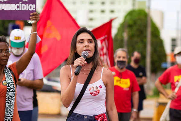 Mikrofona konuşan bir kadın. Fotoğraf, Goiania şehrinde Başkan Bolsonaro 'ya karşı düzenlenen bir protesto sırasında çekildi..