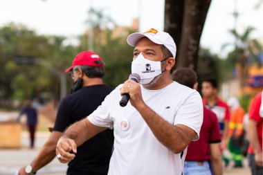 Mikrofona konuşan bir adam. Fotoğraf, Goiania şehrinde Başkan Bolsonaro 'ya karşı düzenlenen bir protesto sırasında çekildi..