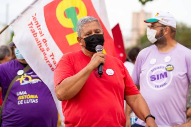Mikrofona konuşan bir adam. Fotoğraf, Goiania şehrinde Başkan Bolsonaro 'ya karşı düzenlenen bir protesto sırasında çekildi..