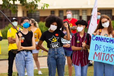 Protestoya katılan bir grup insan. Fotoğraf, Goiania şehrinde Başkan Bolsonaro 'ya karşı düzenlenen bir protesto sırasında çekildi..