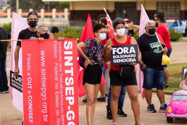 Protestoya katılan bir grup insan. Fotoğraf, Goiania şehrinde Başkan Bolsonaro 'ya karşı düzenlenen bir protesto sırasında çekildi..
