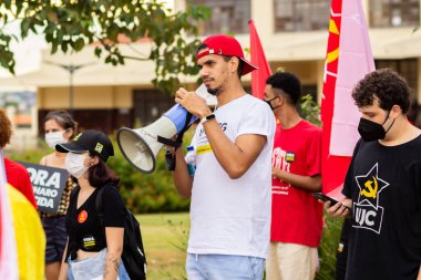 Protestoya katılan bir grup insan. Fotoğraf, Goiania şehrinde Başkan Bolsonaro 'ya karşı düzenlenen bir protesto sırasında çekildi..