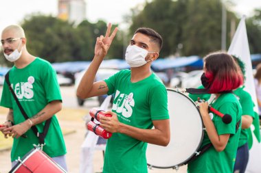 Protestoya katılan bir grup insan. Fotoğraf, Goiania şehrinde Başkan Bolsonaro 'ya karşı düzenlenen bir protesto sırasında çekildi..