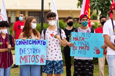 Protestoya katılan bir grup insan. Fotoğraf, Goiania şehrinde Başkan Bolsonaro 'ya karşı düzenlenen bir protesto sırasında çekildi..