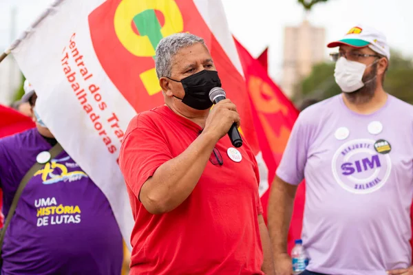 Mikrofona konuşan bir adam. Fotoğraf, Goiania şehrinde Başkan Bolsonaro 'ya karşı düzenlenen bir protesto sırasında çekildi..
