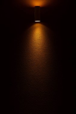 Işıklı arka plan. Sarı desenli beton duvarı aydınlatan bir spot ışığı..