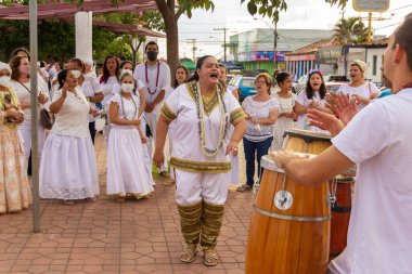 Bazı insanlar Aparecida de Goiania 'daki Yaşlı Siyahların geçit töreninde şarkı söyler, dans eder ve perküsyon enstrümanları çalarlar..