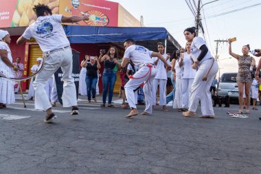Bir grup insan, Aparecida de Goiania 'daki Pretos Velhos geçit töreninde Capoeira savaşını gösteriyor..