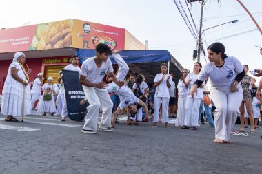 Bir grup insan, Aparecida de Goiania 'daki Pretos Velhos geçit töreninde Capoeira savaşını gösteriyor..