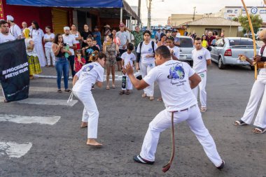 Bir grup insan, Aparecida de Goiania 'daki Yaşlı Siyah Geçit Töreni' nde Capoeira savaşını gösteriyor..