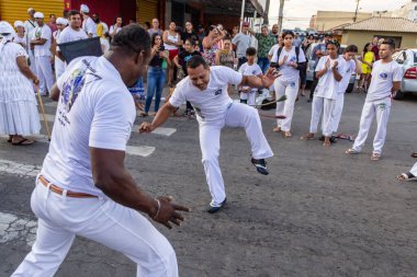 Bir grup insan, Aparecida de Goiania 'daki Yaşlı Siyah Geçit Töreni' nde Capoeira savaşını gösteriyor..