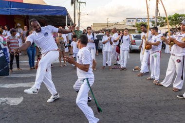 Bir grup insan, Aparecida de Goiania 'daki Yaşlı Siyah Geçit Töreni' nde Capoeira savaşını gösteriyor..
