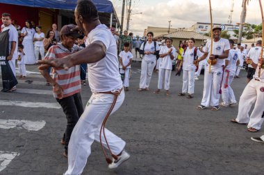 Bir grup insan, Aparecida de Goiania 'daki Yaşlı Siyah Geçit Töreni' nde Capoeira savaşını gösteriyor..